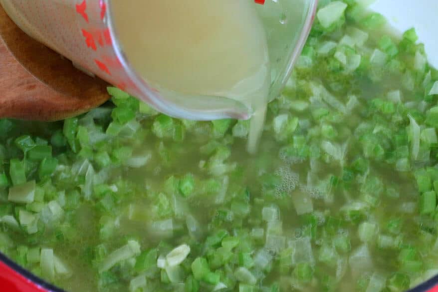 pouring broth into soup