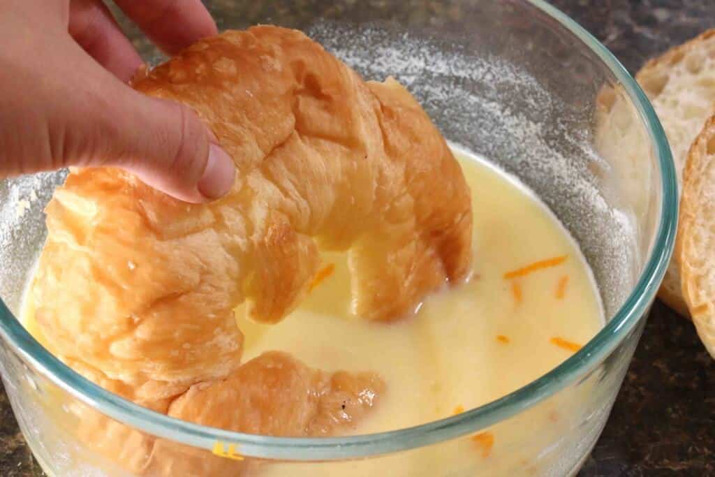dipping croissants in orange milk egg mixture