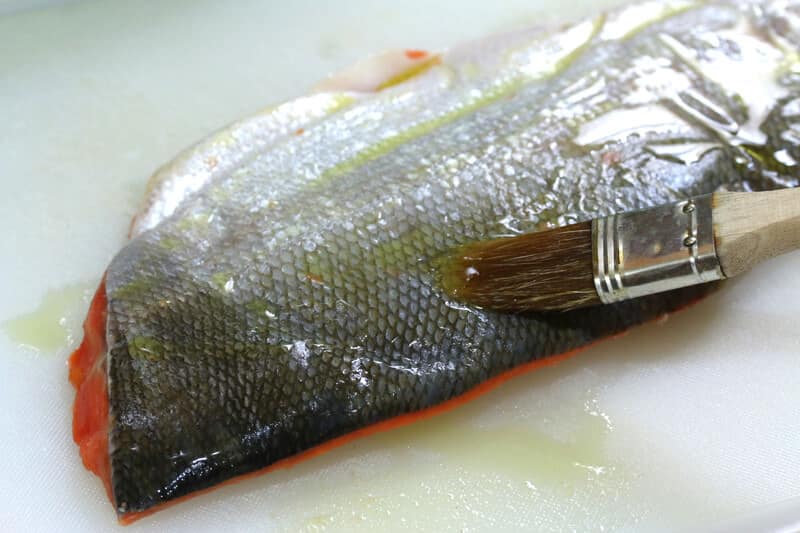 brushing fish with oil