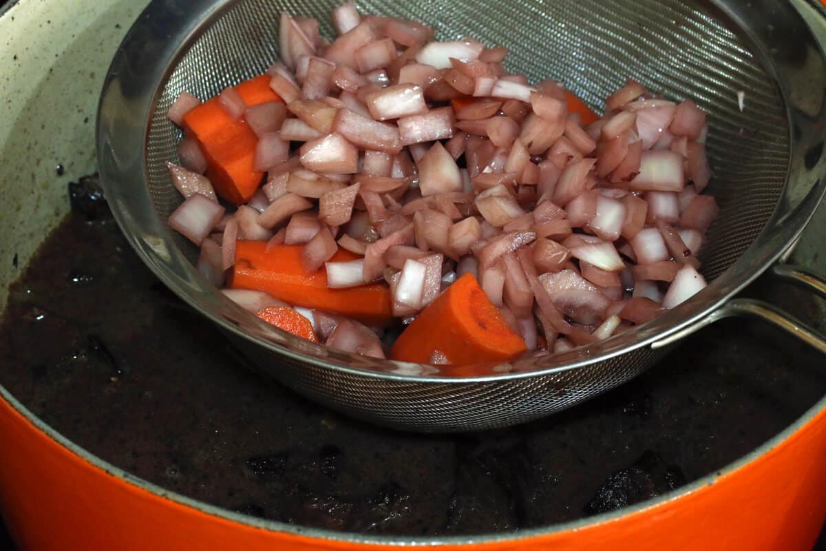 straining the marinated vegetables