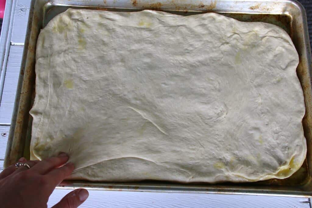 spreading dough onto baking sheet