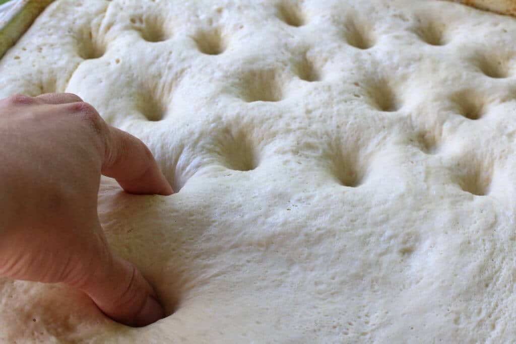 pressing dimples into the dough