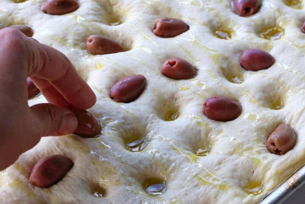 adding olives to dough