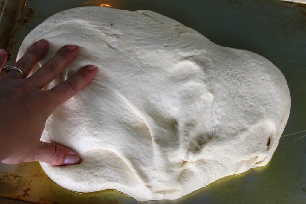 spreading dough out onto baking sheet