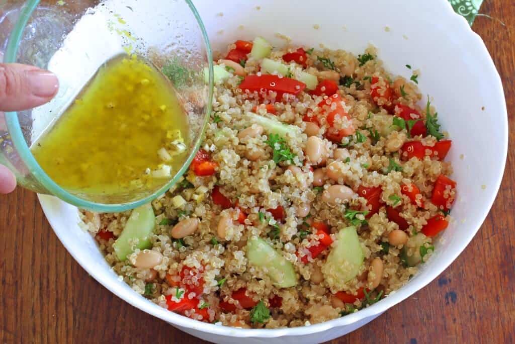 pouring the vinaigrette over the salad