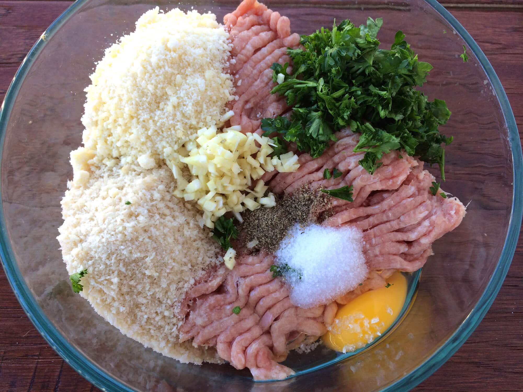 adding ground meat and ingredients to bowl