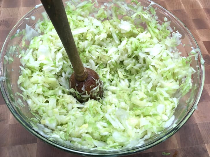 mashing sliced cabbage