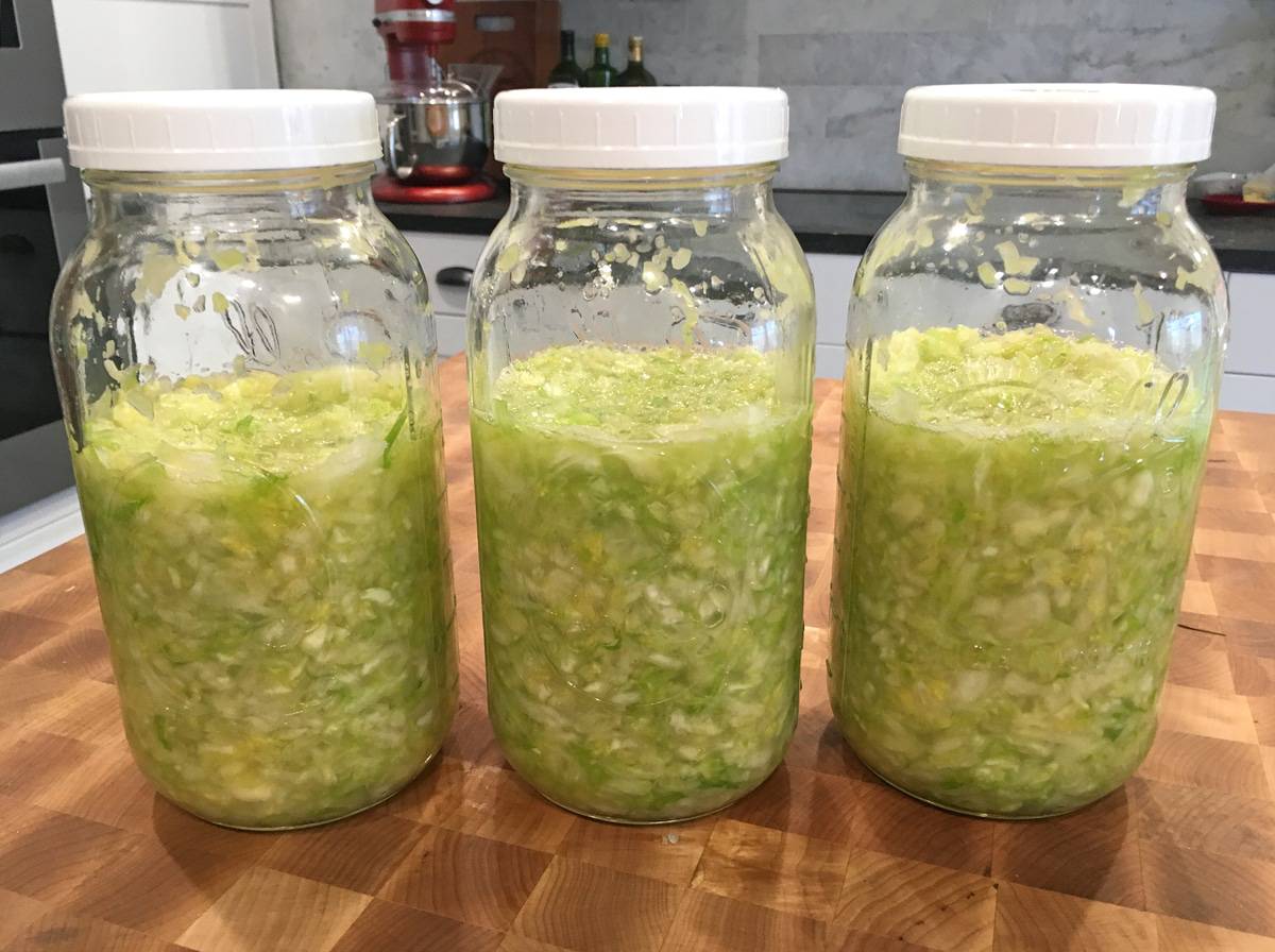 sliced cabbage fermenting in jars