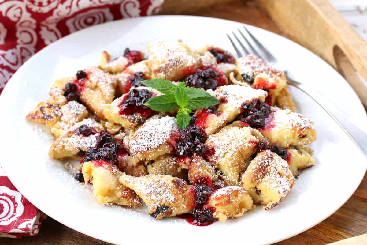 kaiserschmarrn recipe authentic traditional Austrian torn pancakes shredded scrambled rum raisins berries jam compote applesauce plums powdered sugar