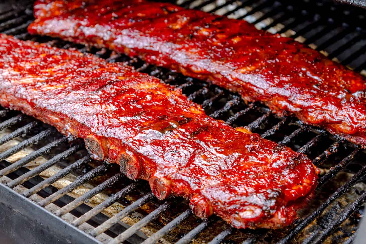 barbecue ribs on grill slathered with bbq sauce