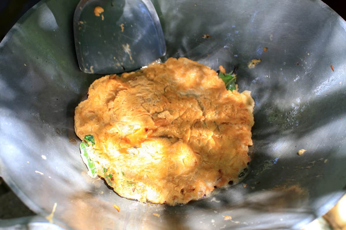 frying chinese omelette in skillet